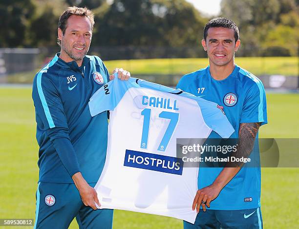 New signing Tim Cahill holds up his new jumper with City head coach John van't Schip during a Melbourne City A-League press conference at La Trobe...