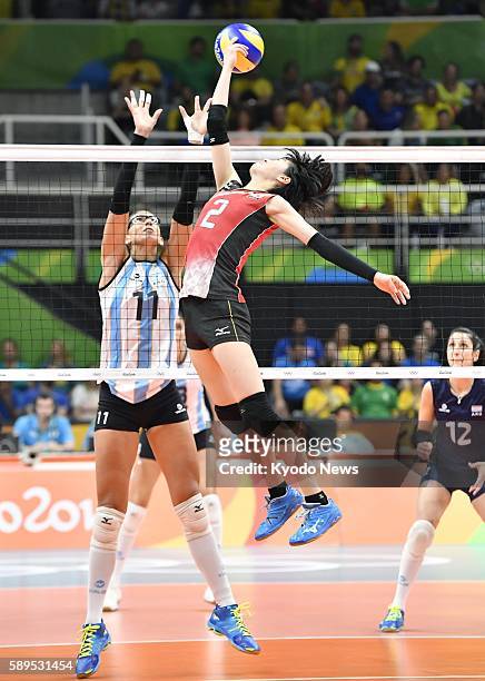 Japan's Haruka Miyashita taps the ball over the net as Argentina's Julieta Lazcano tries to block during the third set of their preliminary-round...