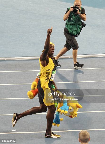 Usain Bolt of Jamaica celebrates his victory after the Athletics men's100m under the camera of great photographer Franck Fife of AFP at Olympic...