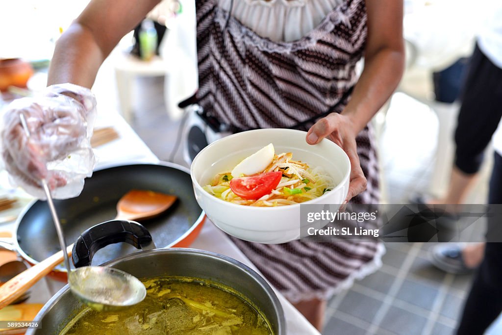 Women preparing noodle soup (Soto ayam, Indonesian cuisine)
