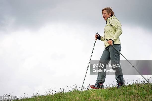 mature woman nordic walking on plateau, slovenia, europe - northern european descent stock pictures, royalty-free photos & images