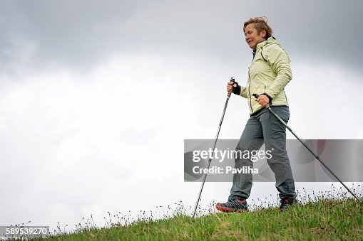 Mature Woman Nordic Walking on Plateau, Slovenia, Europe Mature Woman Nordic Walking on Plateau, Slovenia, Europe