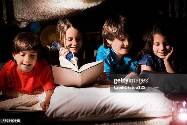 group of children read together in homemade tent at home. - party under stock pictures, royalty-free photos & images