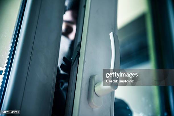 burglar breaks into a residential building - burglary stock pictures, royalty-free photos & images