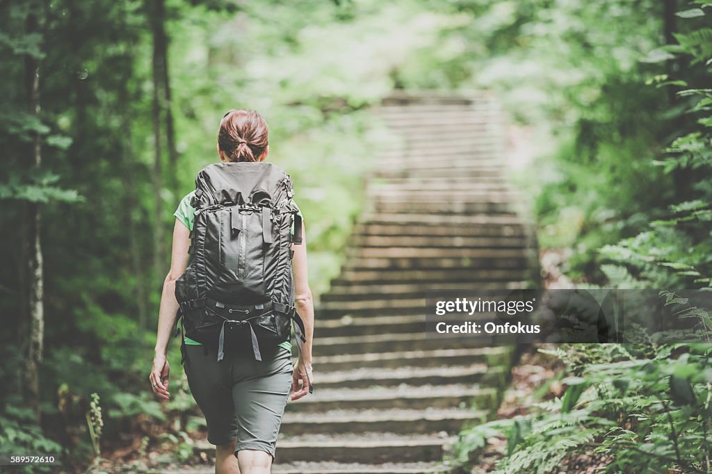 Woman Hiking Trekking with Backpack on Footpath in Forest