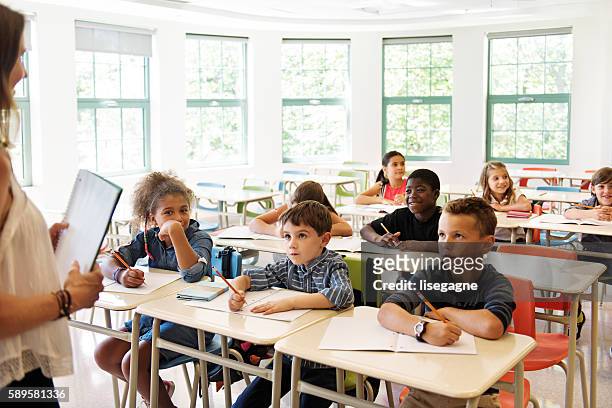 school kids in classroom - elementary school building stock pictures, royalty-free photos & images