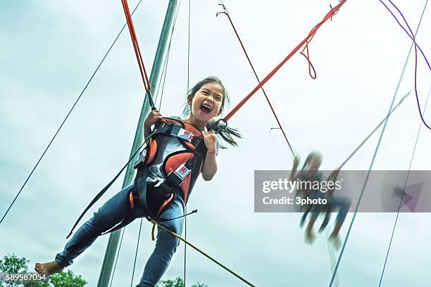 children bungree jumping at trampoline - bungee jump stockfoto's en -beelden