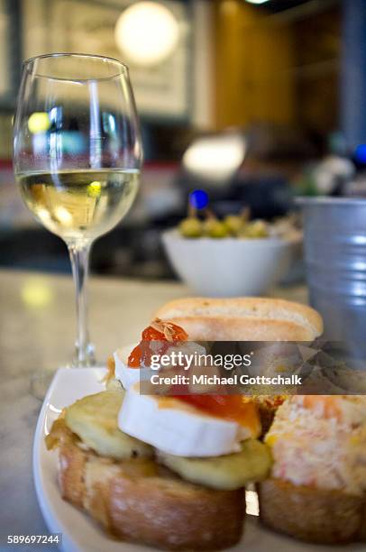 Bilbao, Spain Pintxos, typical nord-spanish slices of bread with different toppings next to a plas of vine on May 12, 2016 in Bilbao, Spain.