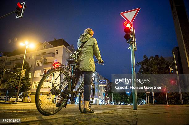 Woman stops riding her bike because of the red traffic light on August 09, 2016 in Berlin, Germany.