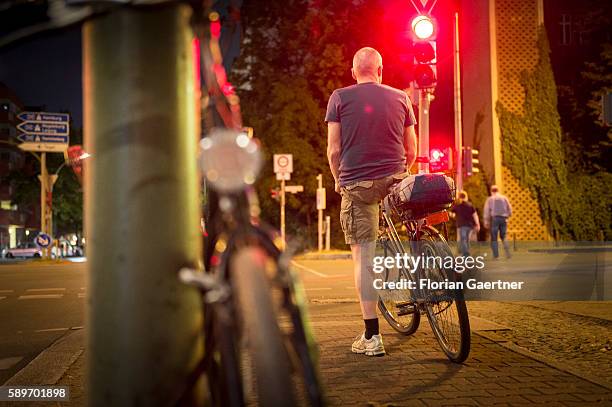 Man stops riding her bike because of the red traffic light on August 09, 2016 in Berlin, Germany.