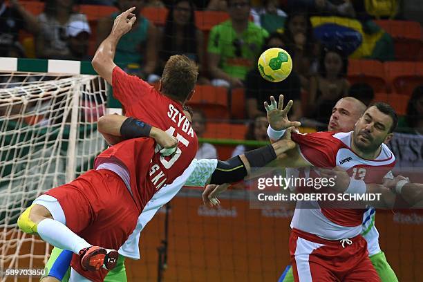 Poland's pivot Bartosz Jurecki vies with a Slovenian player during the men's preliminaries Group B handball match Poland vs Slovenia for the Rio 2016...