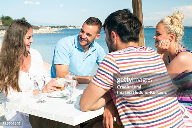 group of friends relaxing in beach bar - beach clear sky stock pictures, royalty-free photos & images