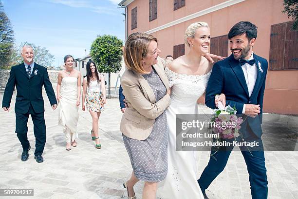 bride and groom walking together with family - bride father stock pictures, royalty-free photos & images