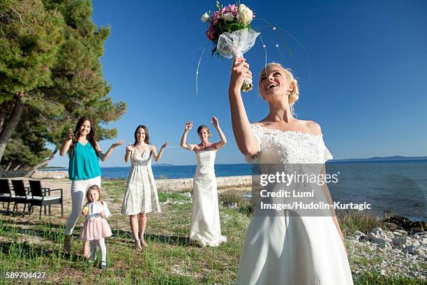 bride throwing bouquet at wedding reception - bouquet toss stock pictures, royalty-free photos & images