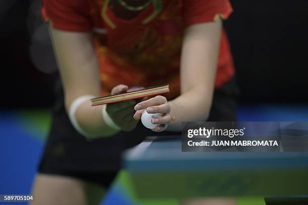 China's Li Xiaoxia prepares to serve in the women's team semi-final table tennis match against Singapore at the Riocentro venue during the Rio 2016...