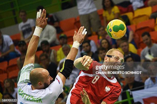 Poland's left back Karol Bielecki vies with Slovenia's right back Vid Kavticnik during the men's preliminaries Group B handball match Poland vs...