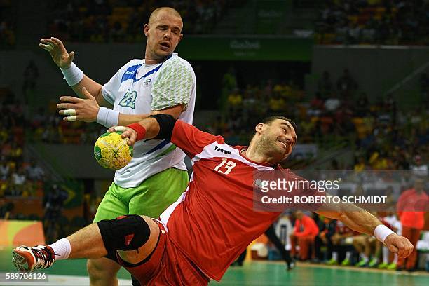 Poland's pivot Bartosz Jurecki shoots past Slovenia's pivot Matej Gaberduring the men's preliminaries Group B handball match Poland vs Slovenia for...