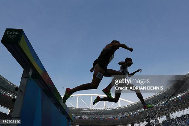 Canada's Matthew Hughes and Turkey's Halil Akkas compete in the Men's 3000m Steeplechase Round 1 during the athletics competition at the Rio 2016...