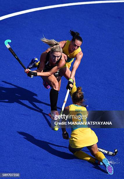 Australia's Brooke Peris and Australia's Madonna Blyth vie with New Zealand's Sophie Cocks during the the women's quarterfinal field hockey New...