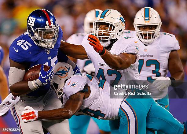 Will Tye of the New York Giants of the New York Giants runs and is tackled by Isa Abdul-Quddus and Spencer Paysinger of the Miami Dolphins during the...