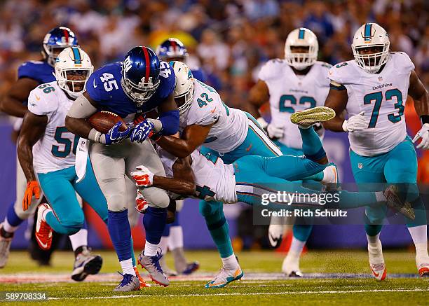 Will Tye of the New York Giants of the New York Giants runs and is tackled by Isa Abdul-Quddus and Spencer Paysinger of the Miami Dolphins during the...