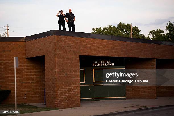 Members of the Milwaukee Police Department keep watch from a boarded up police station the day after protests were sparked by a fatal police involved...