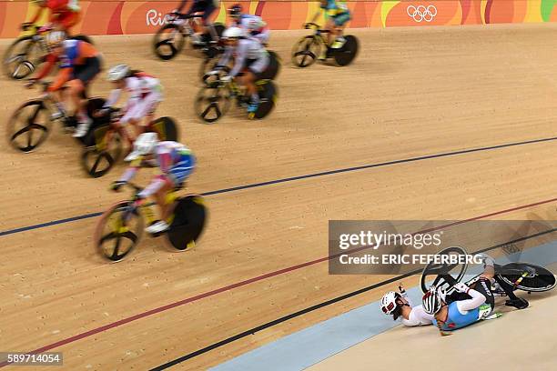 Canada's Allison Beveridge and Germany's Anna Knauer fall during the Women's Omnium Scratch race track cycling event at the Velodrome during the Rio...