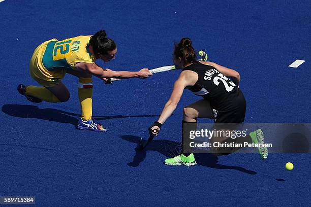 Madonna Blyth of Australia shoots the ball past Kelsey Smith of New Zealand during the second half of the quarter final hockey game on Day 10 of the...