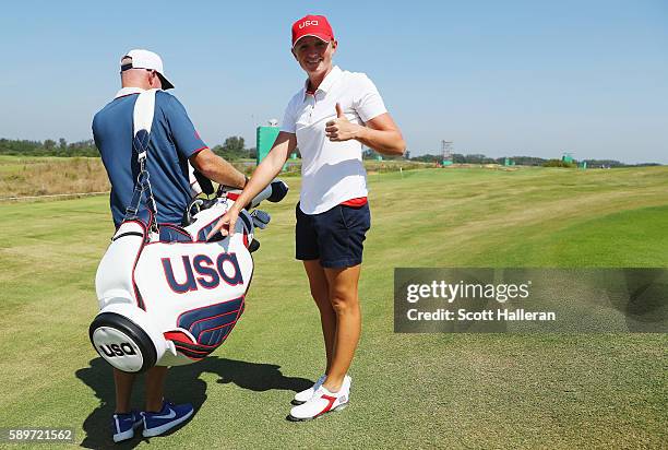 Stacy Lewis of the United States poses with her caddie Travis Wilson during a practice round prior to the start of the women's golf during Day 10 of...