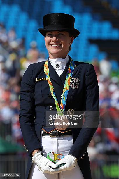 Bronze medalist, Kristina Broring-Sprehe of Germany riding Desperados Frh celebrates on the podium during the medal ceremony of the Dressage...
