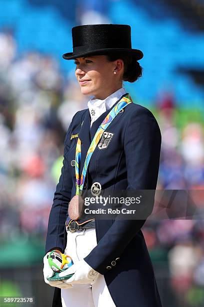 Bronze medalist, Kristina Broring-Sprehe of Germany riding Desperados Frh celebrates on the podium during the medal ceremony of the Dressage...