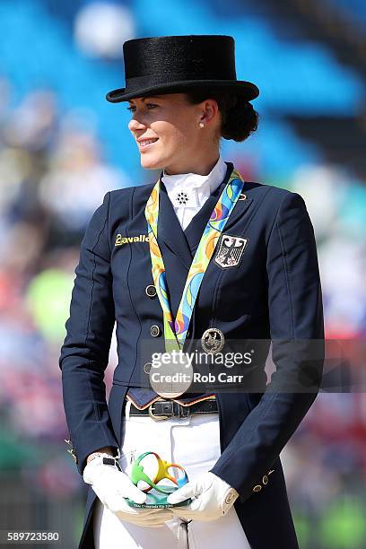 Bronze medalist, Kristina Broring-Sprehe of Germany riding Desperados Frh celebrates on the podium during the medal ceremony of the Dressage...