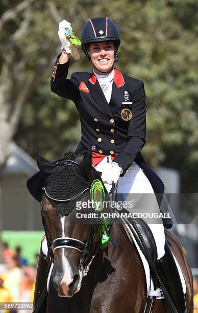 Britain's Charlotte Dujardin on Valegro shows her gold medal after a victory lap in the Equestrian's Dressage Grand Prix Freestyle event of the 2016...