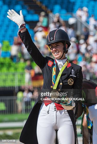 Britain's Charlotte Dujardin waves after receiving her gold medal during the Equestrian's Dressage Grand Prix Freestyle event victory ceremony of the...