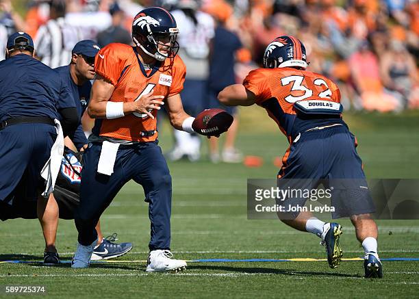 Denver Broncos quarterback Mark Sanchez handoff to Denver Broncos fullback Andy Janovich during practice August 15, 2016 at Dove Valley.