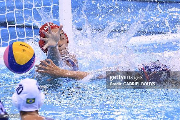 Kiley Neushul scores a goal against Brazil's goalie Victoria Chamorro during their Rio 2016 Olympic Games waterpolo quaterfinal match at the Olympic...