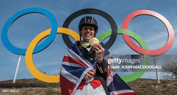 Britain's Charlotte Dujardin poses with her gold medal in front of the Olympic rings after the Equestrian's Dressage Grand Prix Freestyle event of...