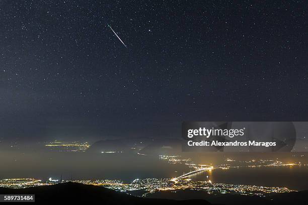 a perseid meteor over the rio-antirio bridge in patras, greece - alexandros maragos stock pictures, royalty-free photos & images