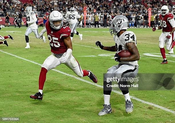 George Atkinson III of the Oakland Raiders breaks a tackle by Marqui Christian of the Arizona Cardinals and scores a second half touchdown at...