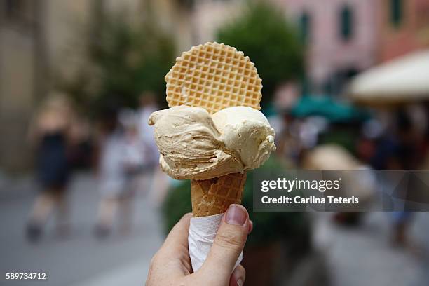 hand holindg two flavoured gelato in an italian piazza - gelato stock pictures, royalty-free photos & images