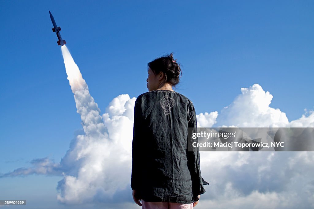 Portrait of a woman against rocket launch
