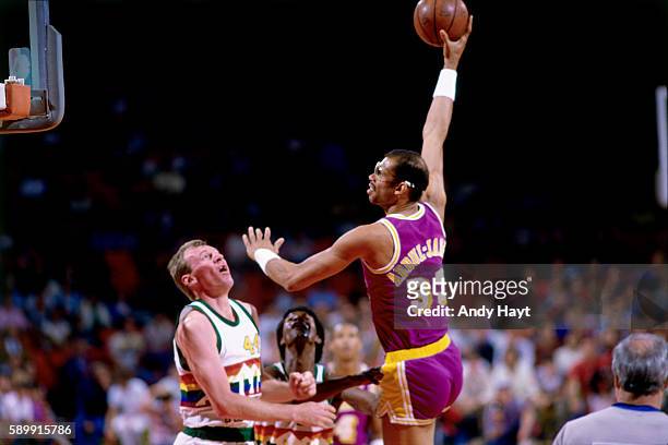 Kareem Abdul-Jabbar of the Los Angeles Lakers shoots the ball against Dan Issel of the Denver Nuggets during a game circa 1983 in Denver, Colorado....