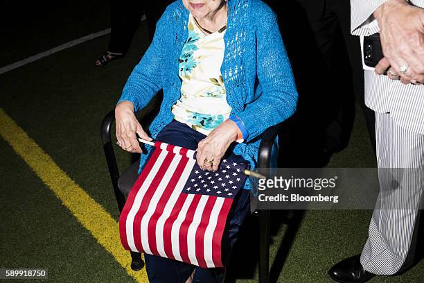 An elderly attendee holds an American flag during a campaign event with Hillary Clinton, 2016 Democratic presidential nominee, not pictured, in...