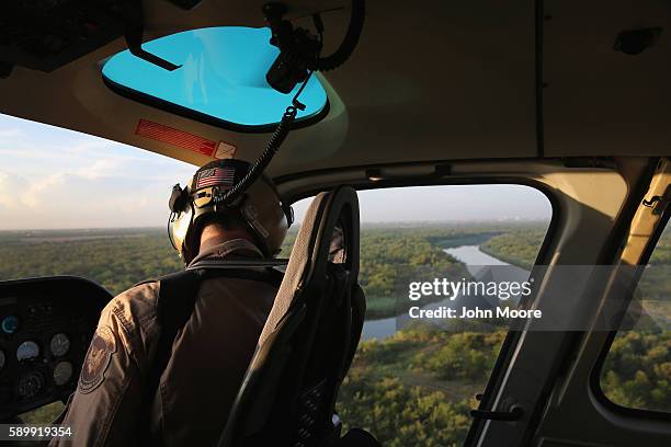 An air interdiction officer with U.S. Customs and Border Protection flies along the Rio Grande at the U.S.-Mexico border on August 15, 2016 near...