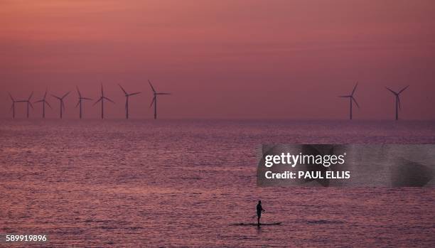 Paddleboarder is pictured on the water near Leasowe at Liverpool Bay in the Irish Sea at sunset on August 15, 2016.