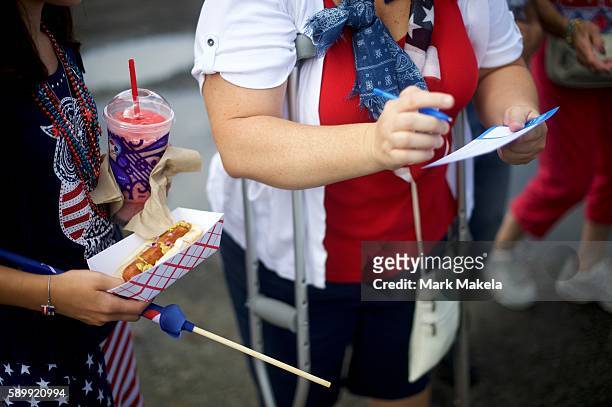 Ryanna Avvisato carries a hot dog while her mother registers with the campaign before the Democratic Presidential candidate holds a rally with Vice...