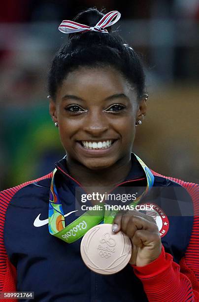 Bronze medallist US gymnast Simone Biles poses on the podium of the women's balance beam event final of the Artistic Gymnastics at the Olympic Arena...