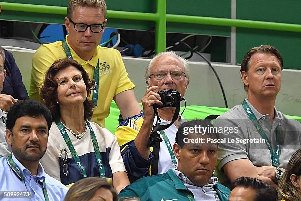 King Carl Gustaf of Sweden takes a picture as Queen Silvia of Sweden and Swedish Olympic Committee President Hans Vestberg sit next to him during the...