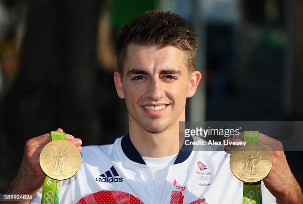 Max Whitlock of Great Britain poses for photographs with his two gold medals in front of the Olympic Park on day 10 on August 15, 2016 in Rio de...