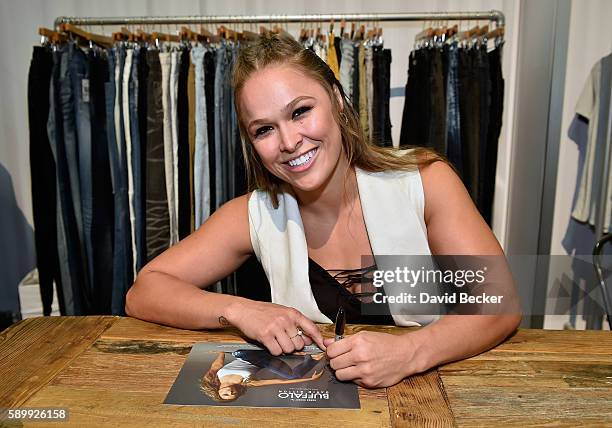 Buffalo David Bitton Brand Ambassador Ronda Rousey signs an autograph at the Buffalo David Bitton booth during Project Vegas at the Mandalay Bay...